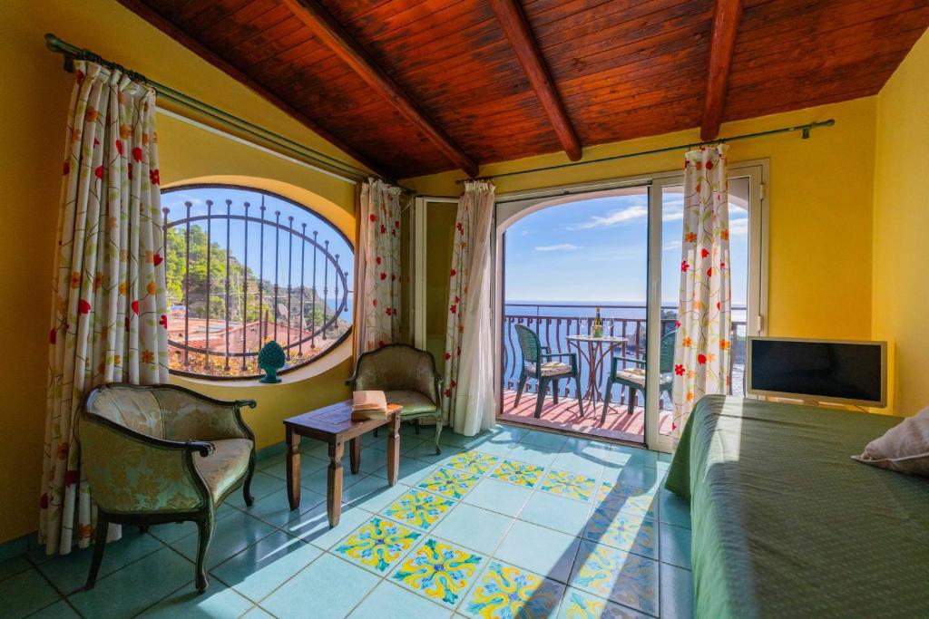 une chambre avec un lit et une vue sur l'océan dans l'établissement Mendolia Beach Hotel, à Taormine