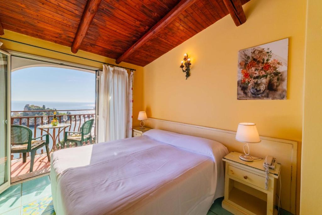une chambre avec un lit et un balcon dans l'établissement Mendolia Beach Hotel, à Taormine