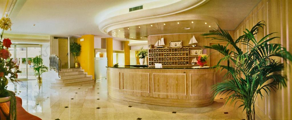 un hall d'entrée avec un bar avec des plantes dedans dans l'établissement Hotel Montecarlo, à Bibione 49 autres photos