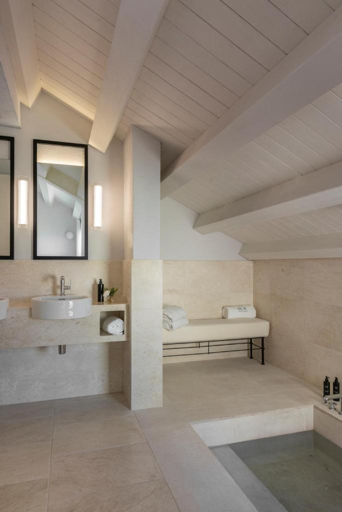 une salle de bain avec un lavabo et un miroir dans l'établissement Hotel Le Dune Piscinas, à Ingurtosu