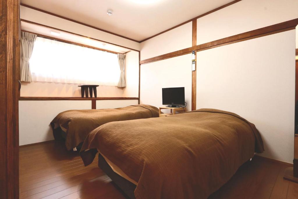 deux lits dans une chambre avec une fenêtre dans l'établissement Hanamizuki, à Yamanakako 37 autres photos