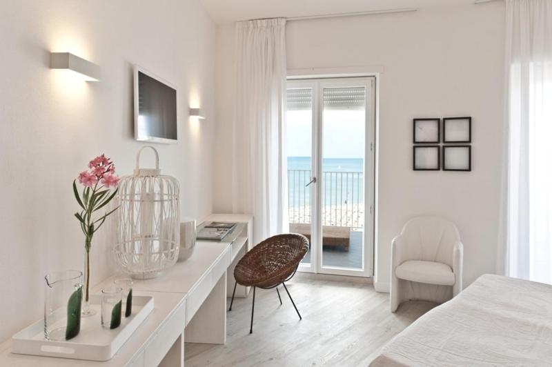 - une chambre blanche avec un bureau, un lit et une fenêtre dans l'établissement Hotel Torremaura, à Milano Marittima