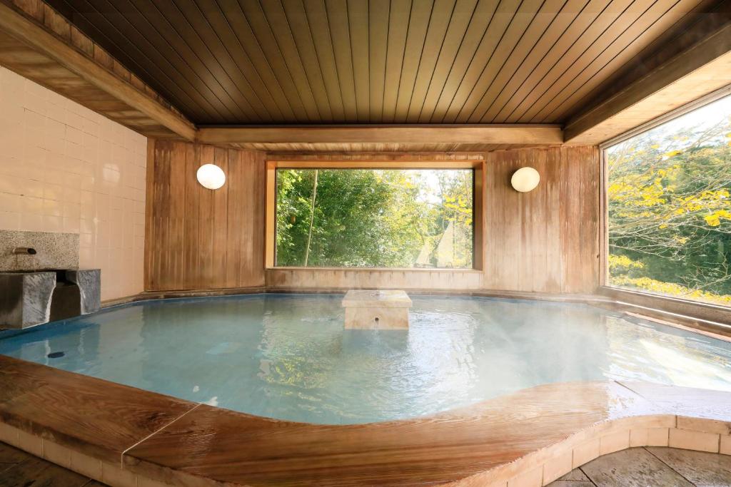 Cette chambre dispose d'une grande piscine et d'une grande fenêtre. dans l'établissement 秘境のおやど 龍峡亭　HIKYOUNOOYADO RYUKYOUTEI, à Tokimata