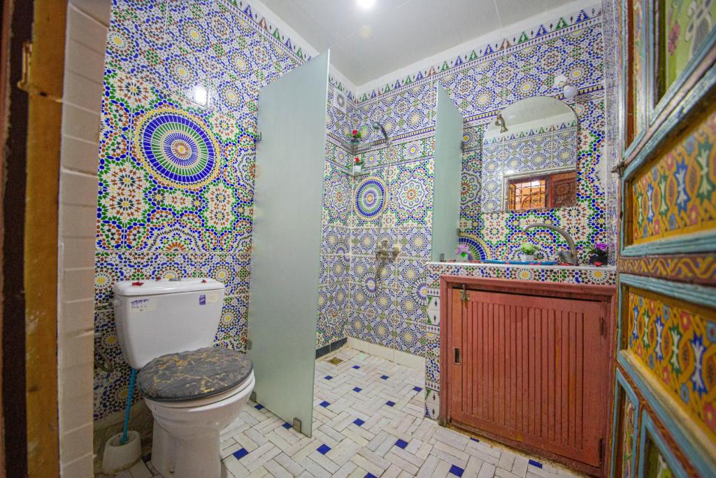 une salle de bain avec toilettes et un mur carrelé dans l'établissement Riad Fes Hayat - Confort Stay, à Fès 37 autres photos