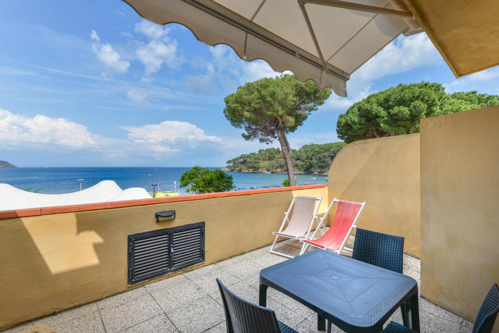 une table et des chaises sur un balcon avec vue sur l'océan dans l'établissement Residence Le Acacie, à Capoliveri