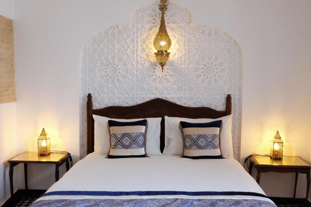 une chambre avec un grand lit avec deux tables de nuit dans l'établissement Riad Alassala Fes, à Fès 36 autres photos