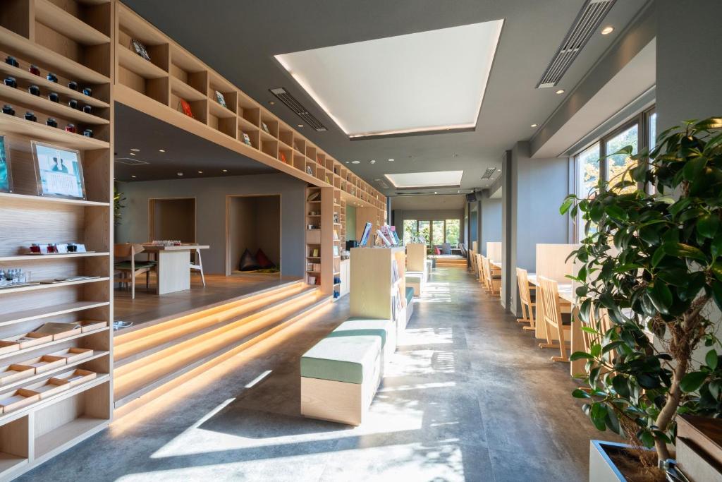 une salle avec des bancs et des tables et une usine dans l'établissement The Ryokan Tokyo YUGAWARA, à Yugawara