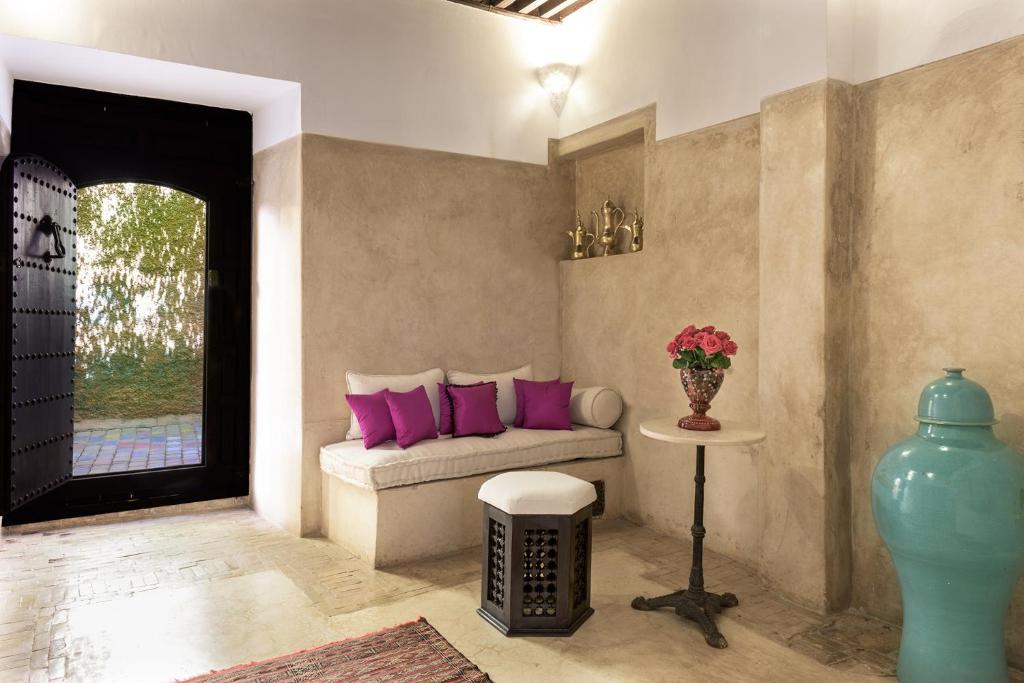 - un salon avec un canapé et des oreillers violets dans l'établissement Riad Hayati, à Marrakech