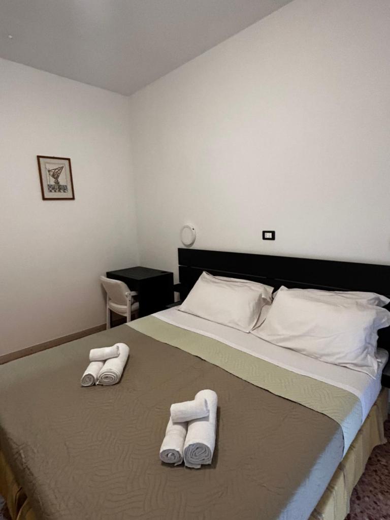 une chambre avec un lit avec deux serviettes dessus dans l'établissement Hotel Perla, à Cesenatico