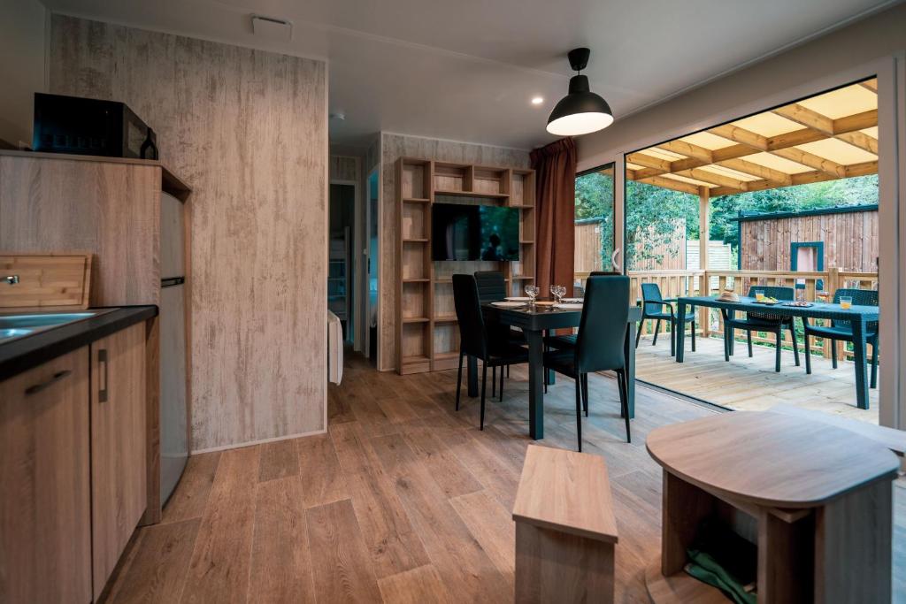 une cuisine et une salle à manger avec une table et des chaises dans l'établissement Camping de l'Orangerie de Lanniron, à Quimper