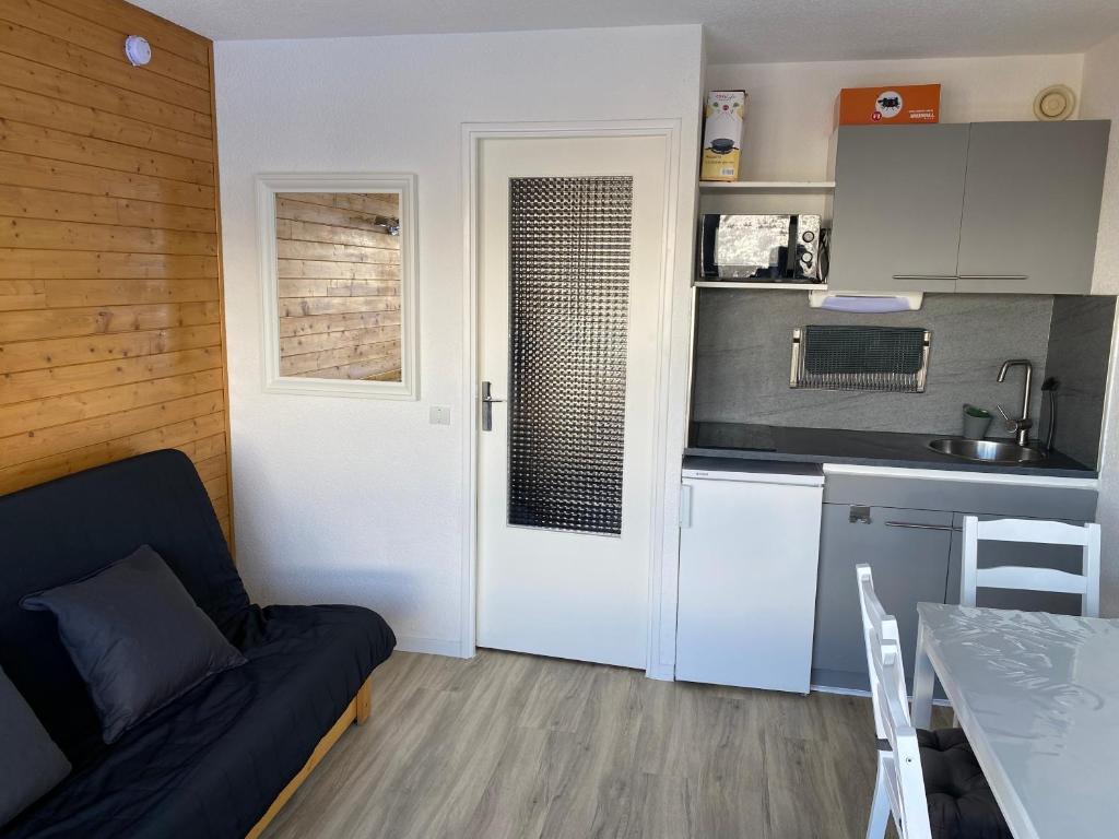 un salon avec un canapé et une cuisine dans l'établissement Studio Puy Saint Vincent 1600 aux pieds des pistes, à Puy-Saint-Vincent 29 autres photos