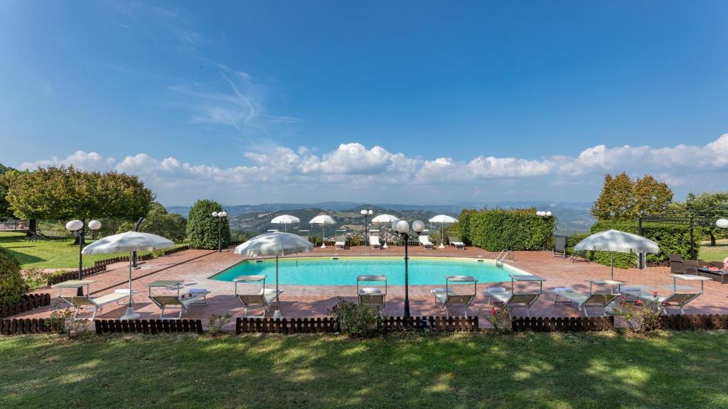 une grande piscine avec chaises et parasols dans l'établissement TENUTA MONTIEPOLI 12&3, Emma Villas, à Valfabbrica