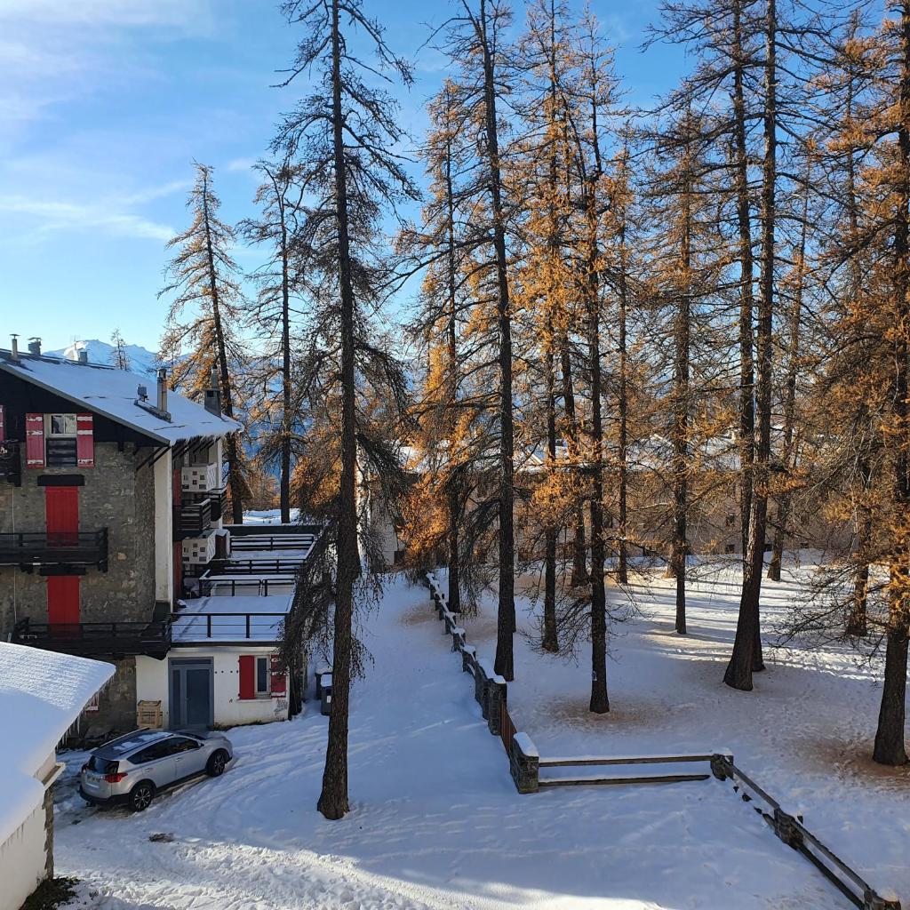 - une vue sur une maison dans la neige avec une voiture dans l'établissement Studio Hyper centre Valberg, à Valberg