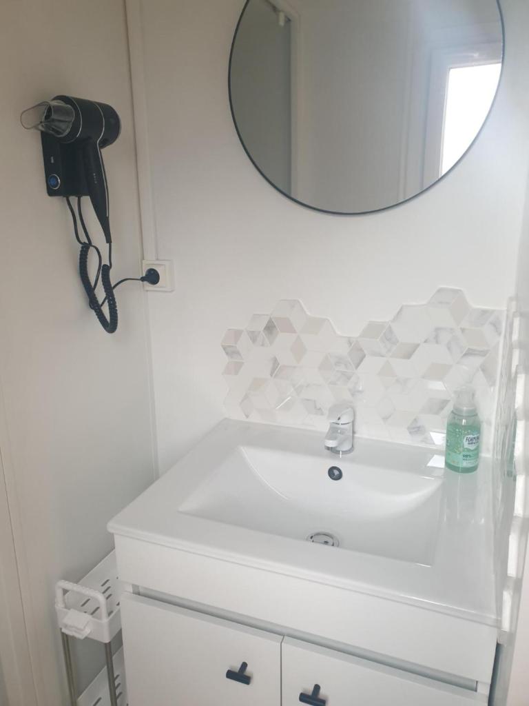 une salle de bain avec un lavabo blanc et un miroir dans l'établissement Camping Domaine des Iscles, à La Roque-dʼAnthéron