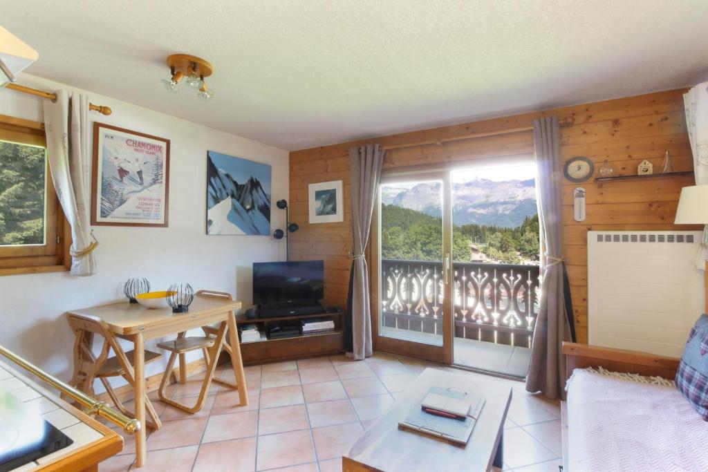 d'un salon avec une table et un balcon. dans l'établissement Prarion ski in ski out and swimming pool !, aux Houches