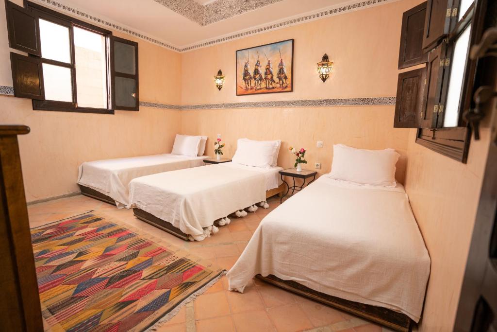 une chambre avec deux lits et un tapis dans l'établissement Riad Atlas Toyours, à Marrakech