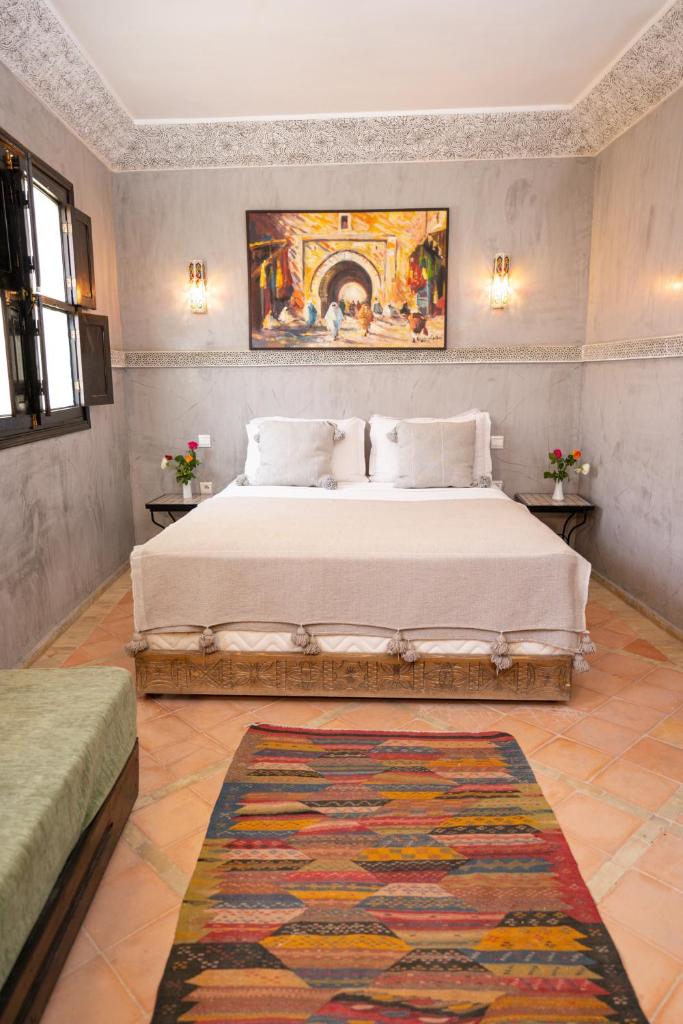 une chambre avec un lit et un tableau au mur dans l'établissement Riad Atlas Toyours, à Marrakech