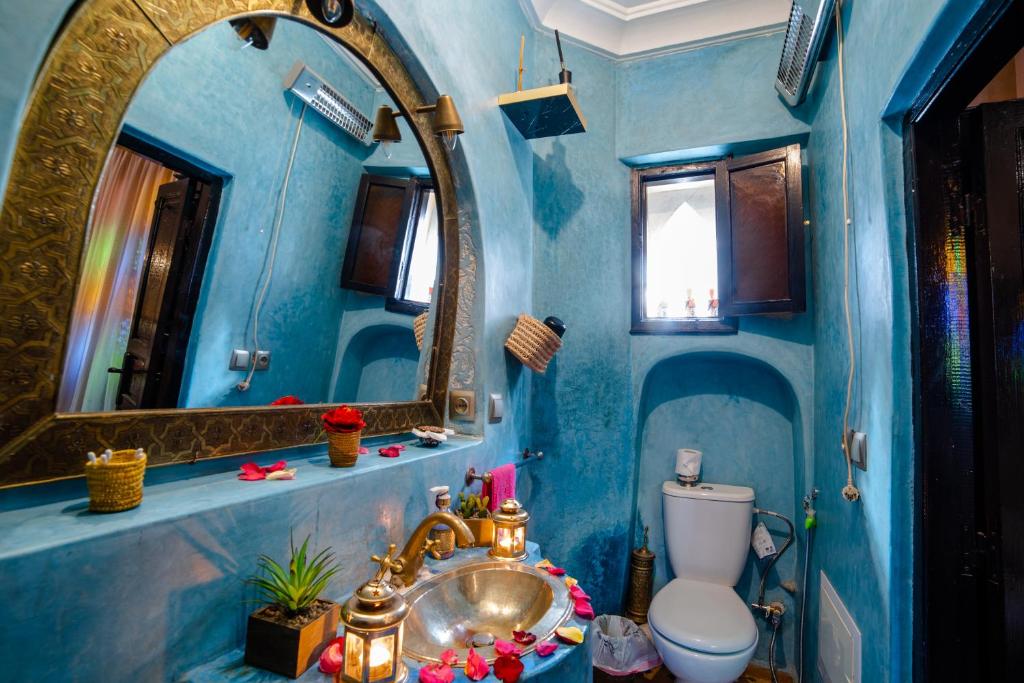 une salle de bain bleue avec un lavabo et des toilettes dans l'établissement Riad Eva, à Marrakech