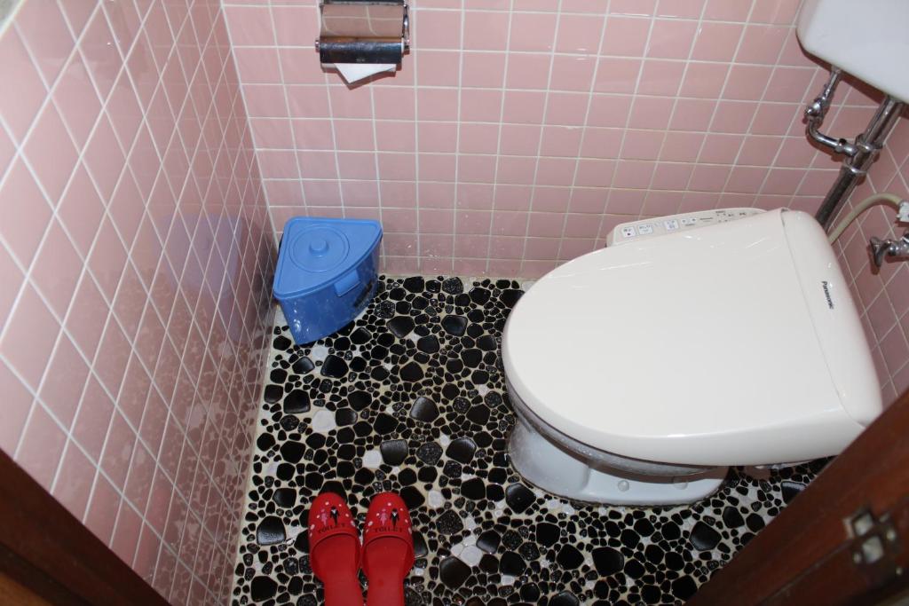 La salle de bains est pourvue de toilettes et d'une paire de chaussures rouges. dans l'établissement Yamadaya Hotel, à Fujikawaguchiko 27 autres photos