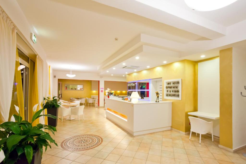 un hall d'un hôtel avec un comptoir et des chaises dans l'établissement Hotel Ca' D'Oro, à Caorle