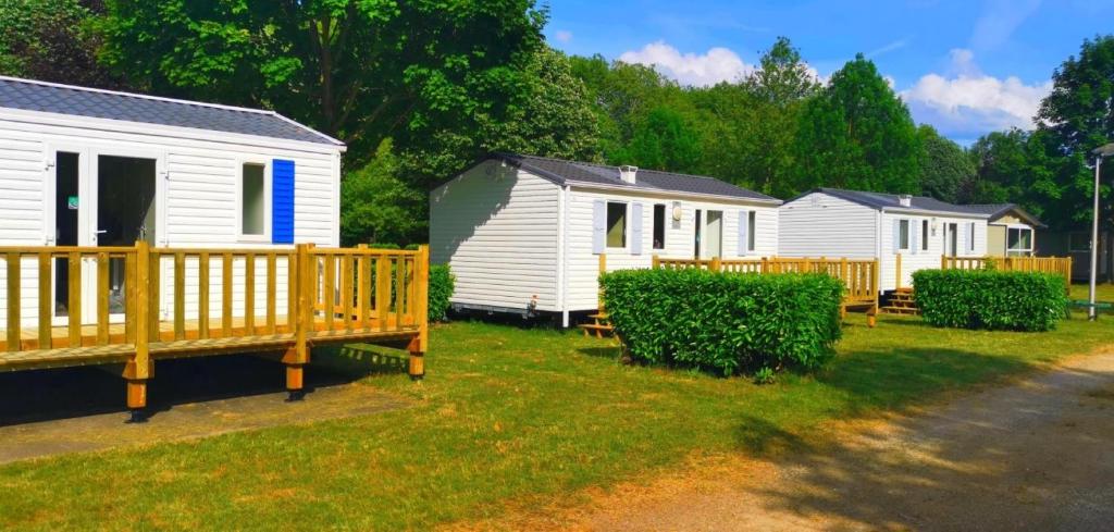 Une rangée de mobile homes blancs dans une cour dans l'établissement Camping le Martinet, à Briare