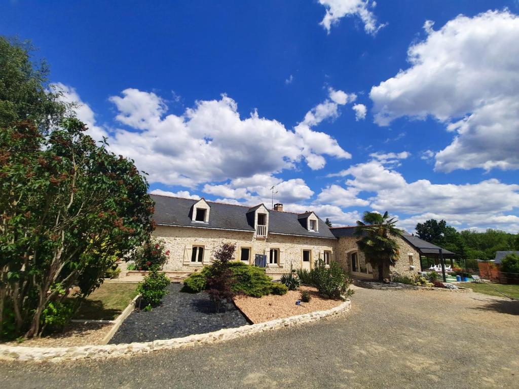 une grande maison avec une allée devant dans l'établissement O'gîte Bleu pour 14 personnes, à Huillé