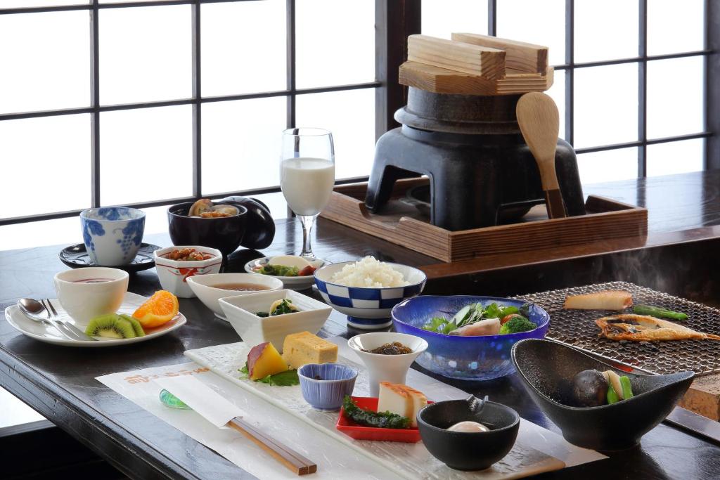 une table recouverte de bols et de assiettes de nourriture dans l'établissement Yamayuri no Yado, à Hanamaki