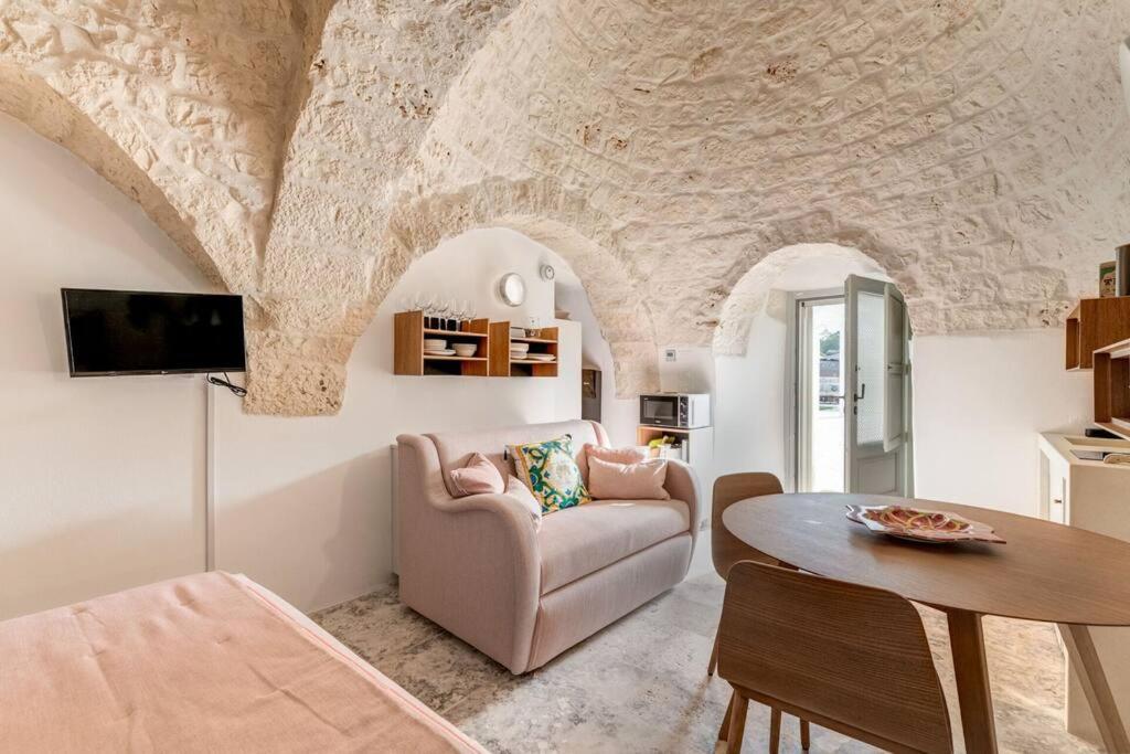 un salon avec un canapé et une table dans l'établissement Trullo Under The Apulian Sky By Raro Villas, à Martina Franca