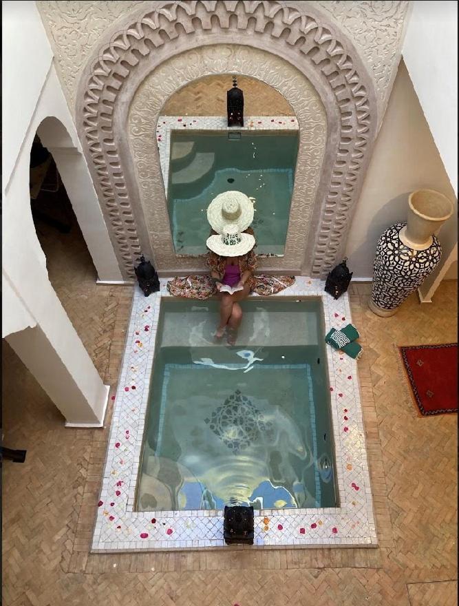 une personne debout dans une piscine dans une maison dans l'établissement Riad KaBaYa Charme Exclusif Privatisé 2 à 8 Pers., à Marrakech