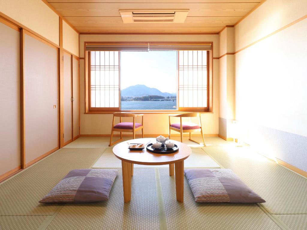 une pièce avec une table et des chaises et une grande fenêtre dans l'établissement Hotel Asafuji, à Fujikawaguchiko
