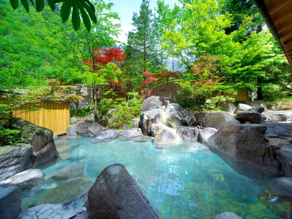une piscine d'eau avec des rochers dans un jardin dans l'établissement Hotel Hotaka, à Takayama