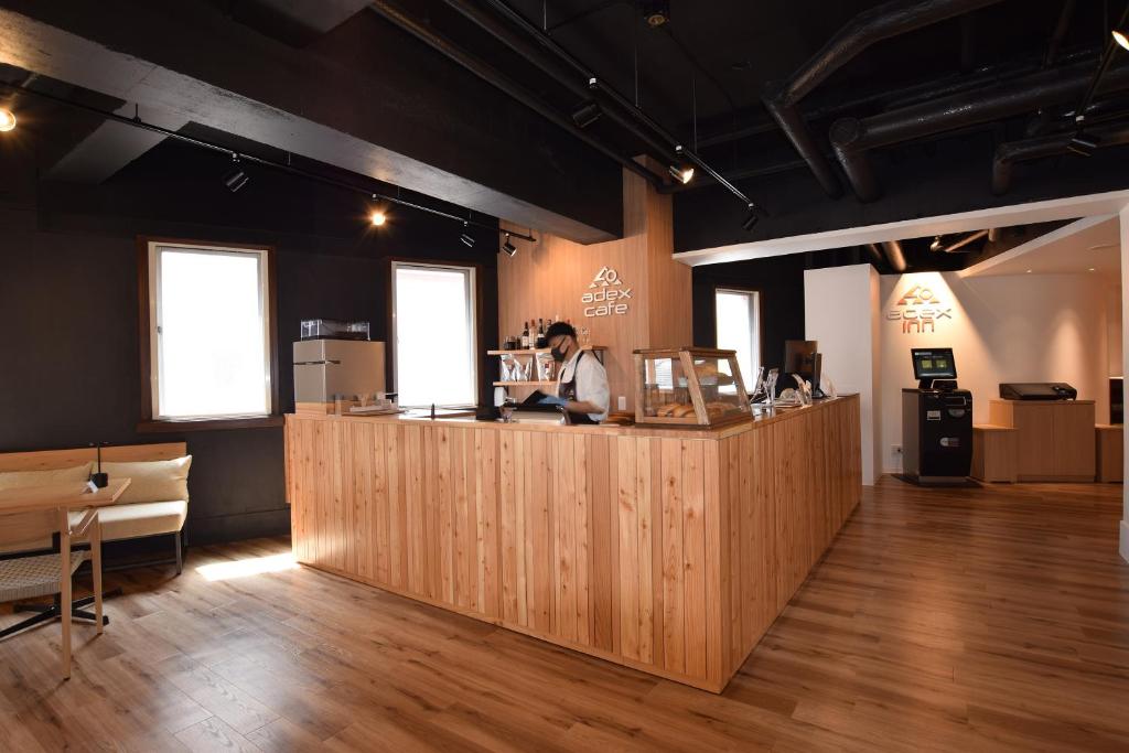 Un homme debout au comptoir d'un restaurant dans l'établissement adex Inn, à Noboribetsu