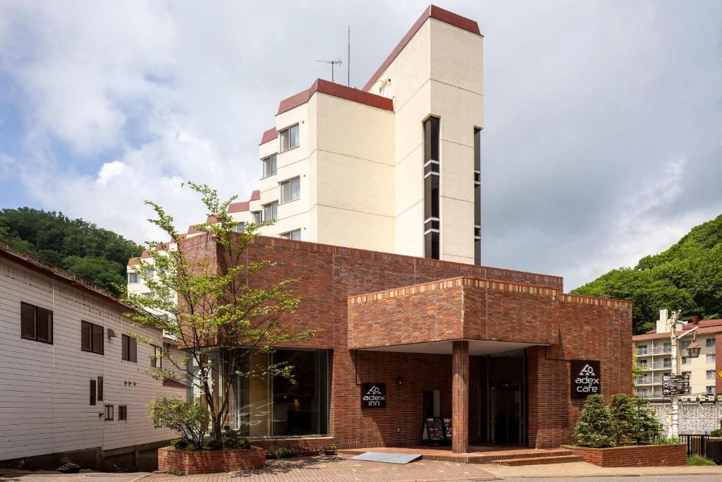 un bâtiment en briques avec une tour en haut dans l'établissement adex Inn, à Noboribetsu