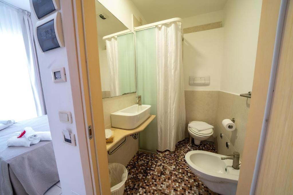 une salle de bain avec un lavabo et des toilettes dans l'établissement Gargano Hotel Helios, à Rodi Garganico