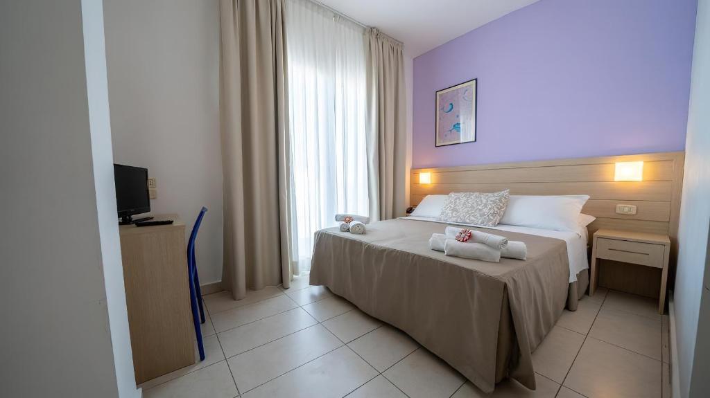 une chambre avec un lit avec deux ours en peluche dessus dans l'établissement Gargano Hotel Helios, à Rodi Garganico