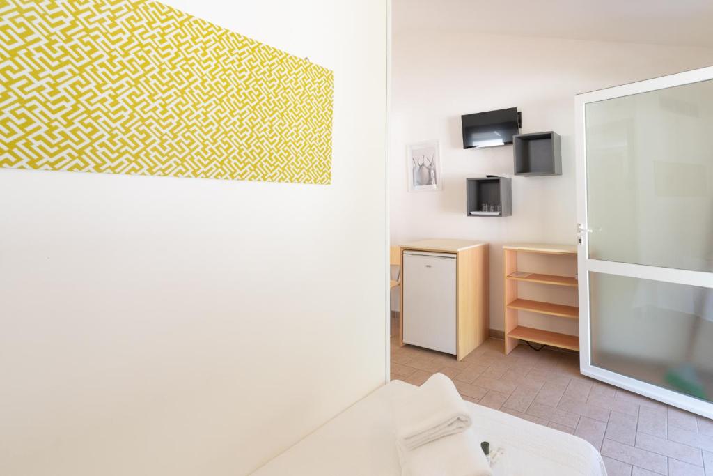 La salle de bains est pourvue d'un mur jaune et blanc. dans l'établissement Golfo di Maremma Village, à Albinia