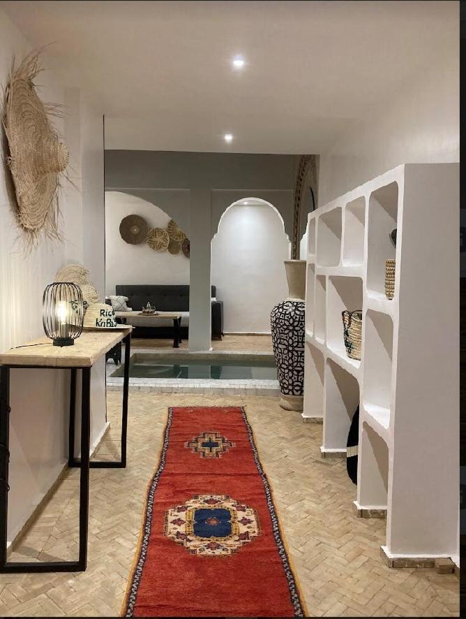 - un salon avec une table et un tapis dans l'établissement Riad KaBaYa Charme Exclusif Privatisé 2 à 8 Pers., à Marrakech