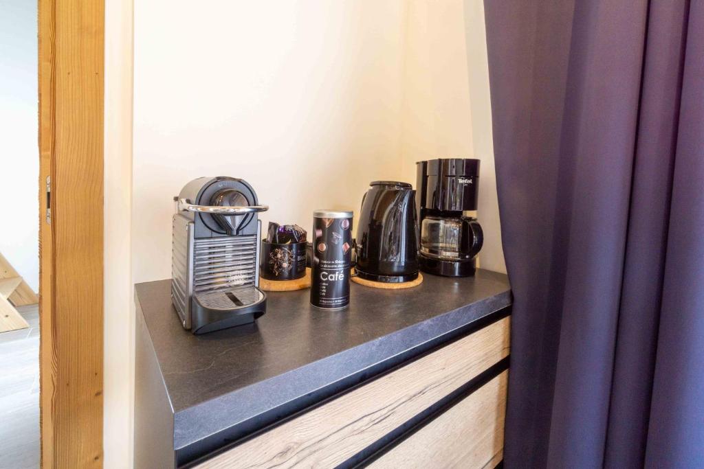 - une étagère avec une cafetière et des cafés dans l'établissement Chalet la Parrachée, à Lanslebourg-Mont-Cenis