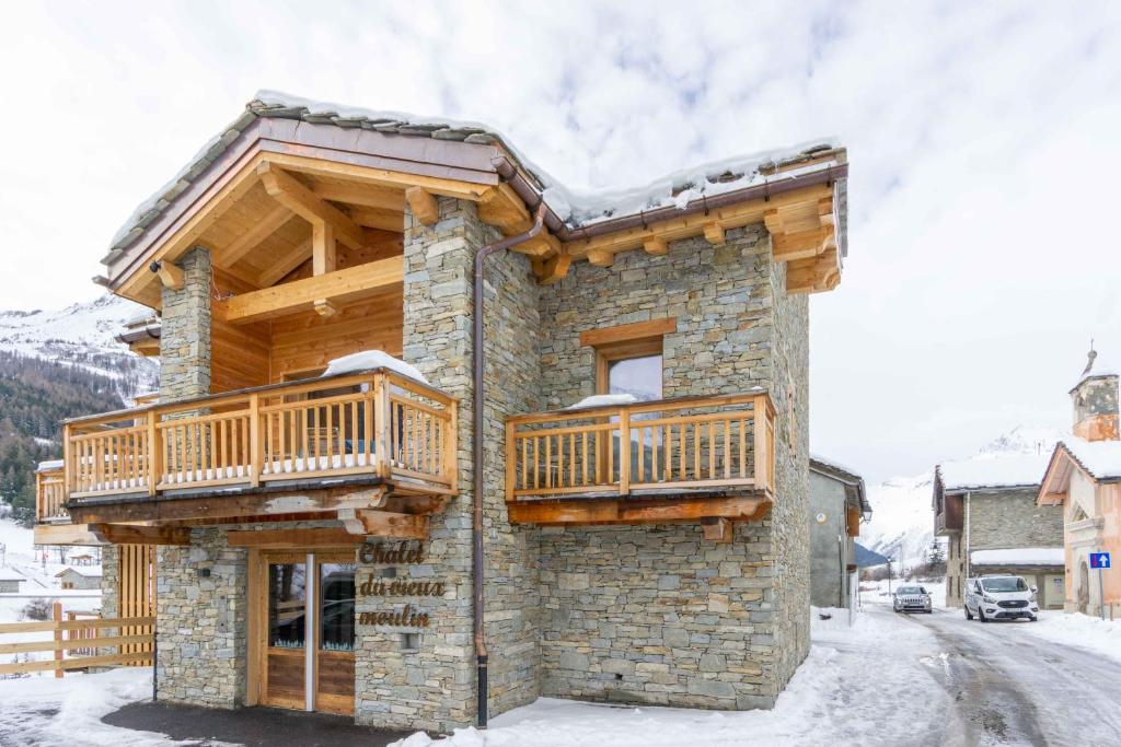 une cabane en rondins avec deux terrasses latérales dans l'établissement Chalet la Parrachée, à Lanslebourg-Mont-Cenis