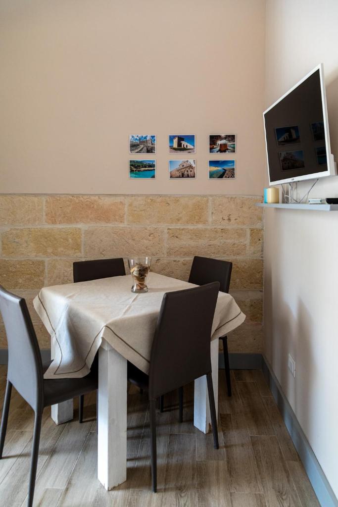 une salle à manger avec une table avec des chaises et une télévision dans l'établissement Lido degli Angeli Case Vacanza-Beach, à Punta Prosciutto