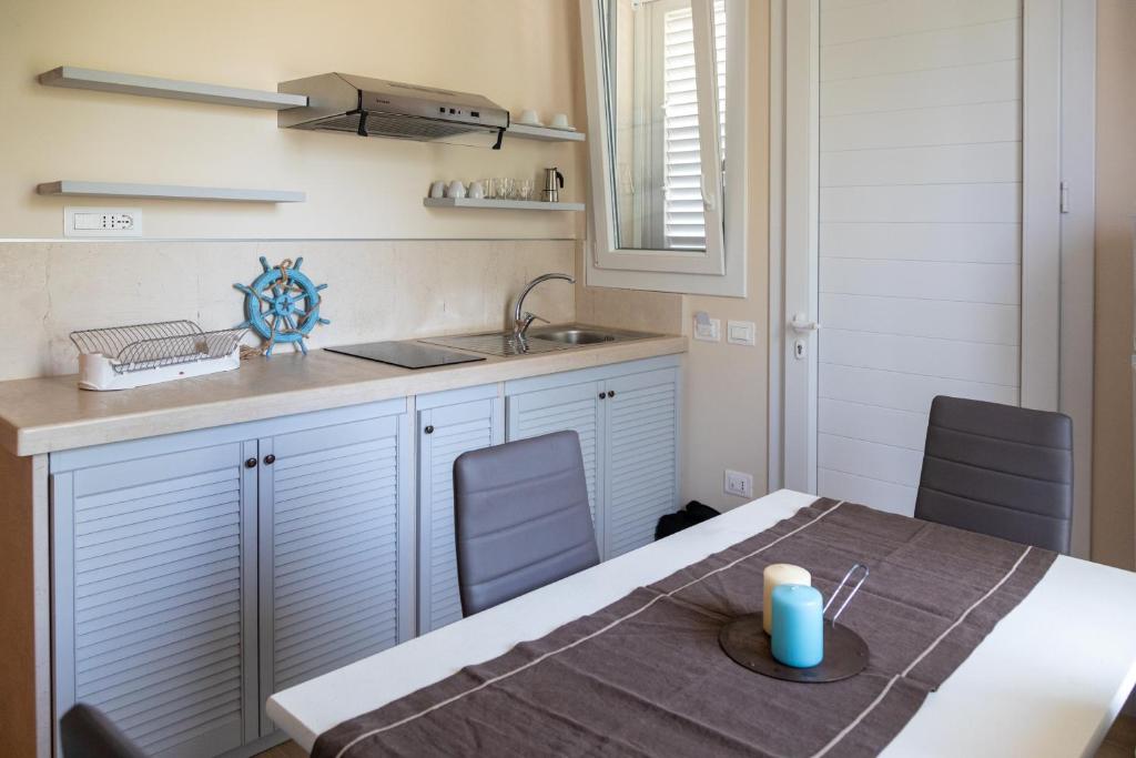 - une cuisine avec une table et un évier dans l'établissement Lido degli Angeli Case Vacanza-Beach, à Punta Prosciutto 151 autres photos