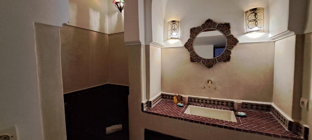 une salle de bain avec un lavabo et un miroir au mur dans l'établissement Riad Parfum d'Orient, à Marrakech