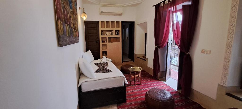 un salon avec un lit et une fenêtre dans l'établissement Riad Parfum d'Orient, à Marrakech