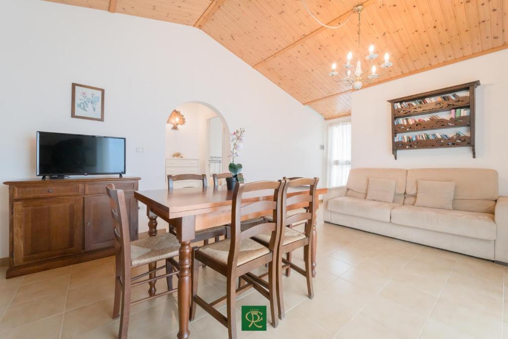 une salle à manger avec une table, des chaises et un canapé dans l'établissement Albatros, à Capoliveri