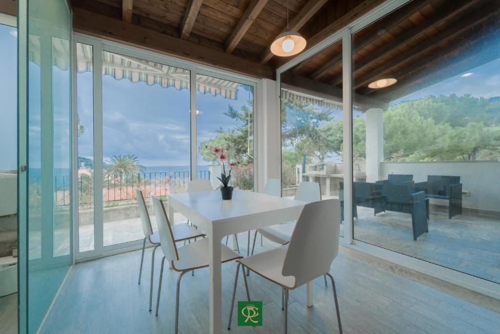 une salle à manger avec une table et des chaises blanches dans l'établissement Albatros, à Capoliveri