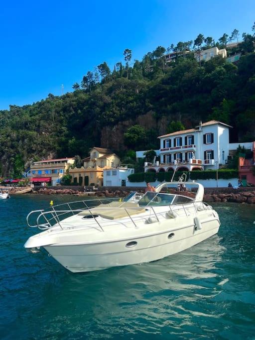 un bateau blanc flottant dans l'eau près d'une ville dans l'établissement Séjour Côte d'Azur sur un navire de plaisance, à Mandelieu-la-Napoule
