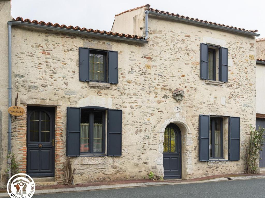 une ancienne maison en pierre avec volets noirs dans l'établissement Maison rénovée avec jardin, piscine chauffée et wifi à Mareuil-sur-Lay - FR-1-426-537, à Mareuil-sur-Lay