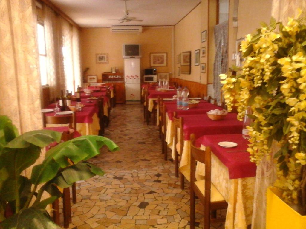 une longue rangée de tables dans un restaurant avec des nappes rouges dans l'établissement Villa Lavinia, à Rimini 49 autres photos