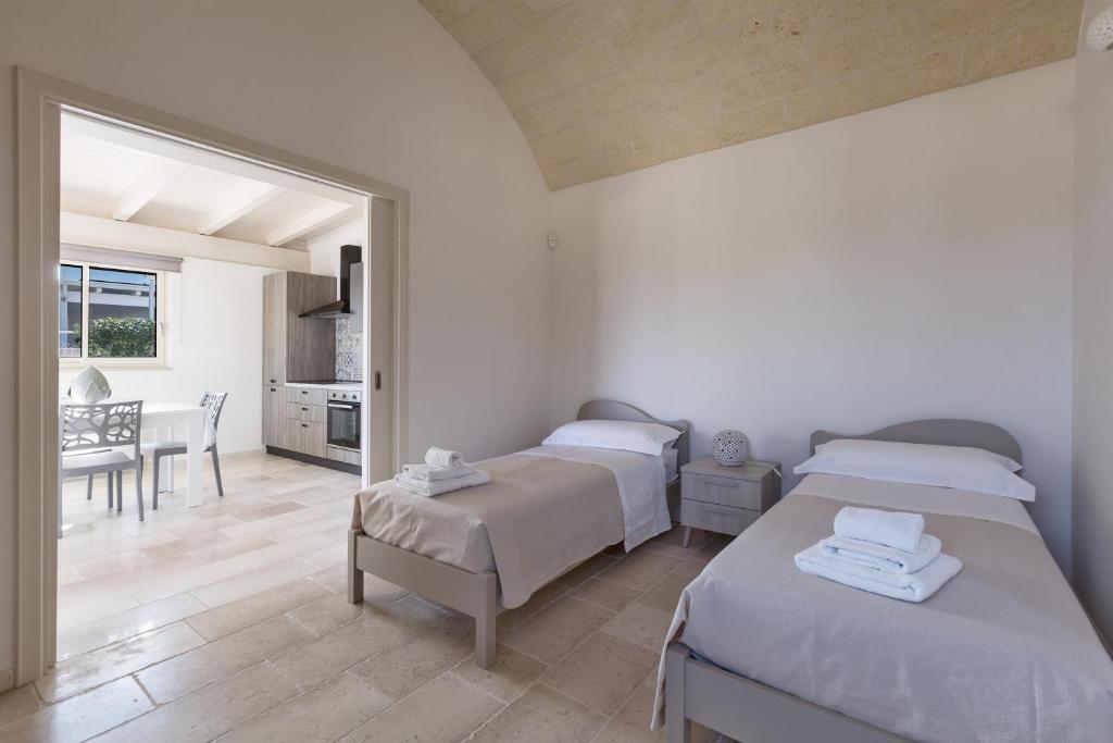 - une chambre avec deux lits et une salle à manger dans l'établissement Villa Angi by Perle di Puglia, à San Vito dei Normanni