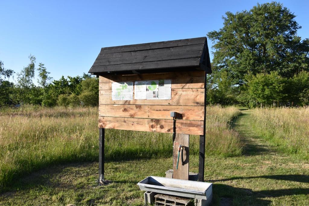 un nichoir en bois posé dans un champ dans l'établissement Charmecamping Domaine Bleu Celeste, à Couleuvre